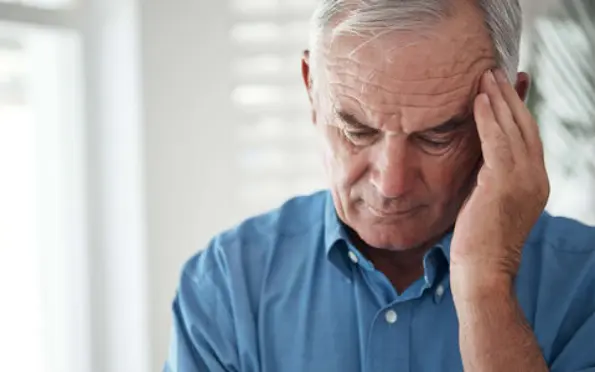 Homme âgé qui se tient la tête